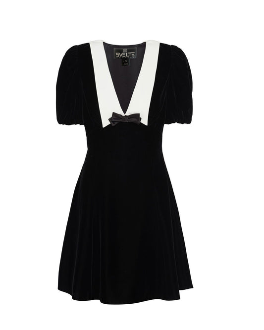 A black velvet dress with off-shoulder design and a bow detail on the shoulder.