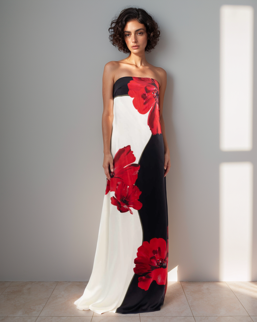 Woman wearing a strapless dress with red floral patterns against a neutral background