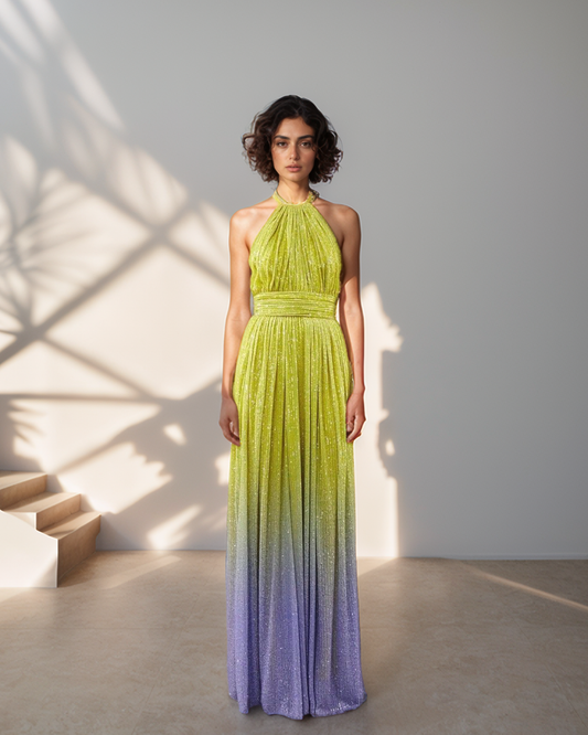 Woman wearing a gradient green and purple dress standing in a well-lit room.