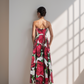 Woman wearing a strapless floral dress standing in a sunlit room.