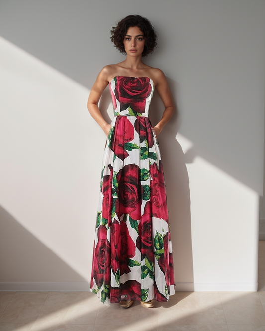 Woman wearing a strapless dress with red rose pattern against a plain background