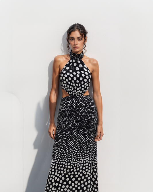 Woman wearing a black and white polka dot dress against a light background