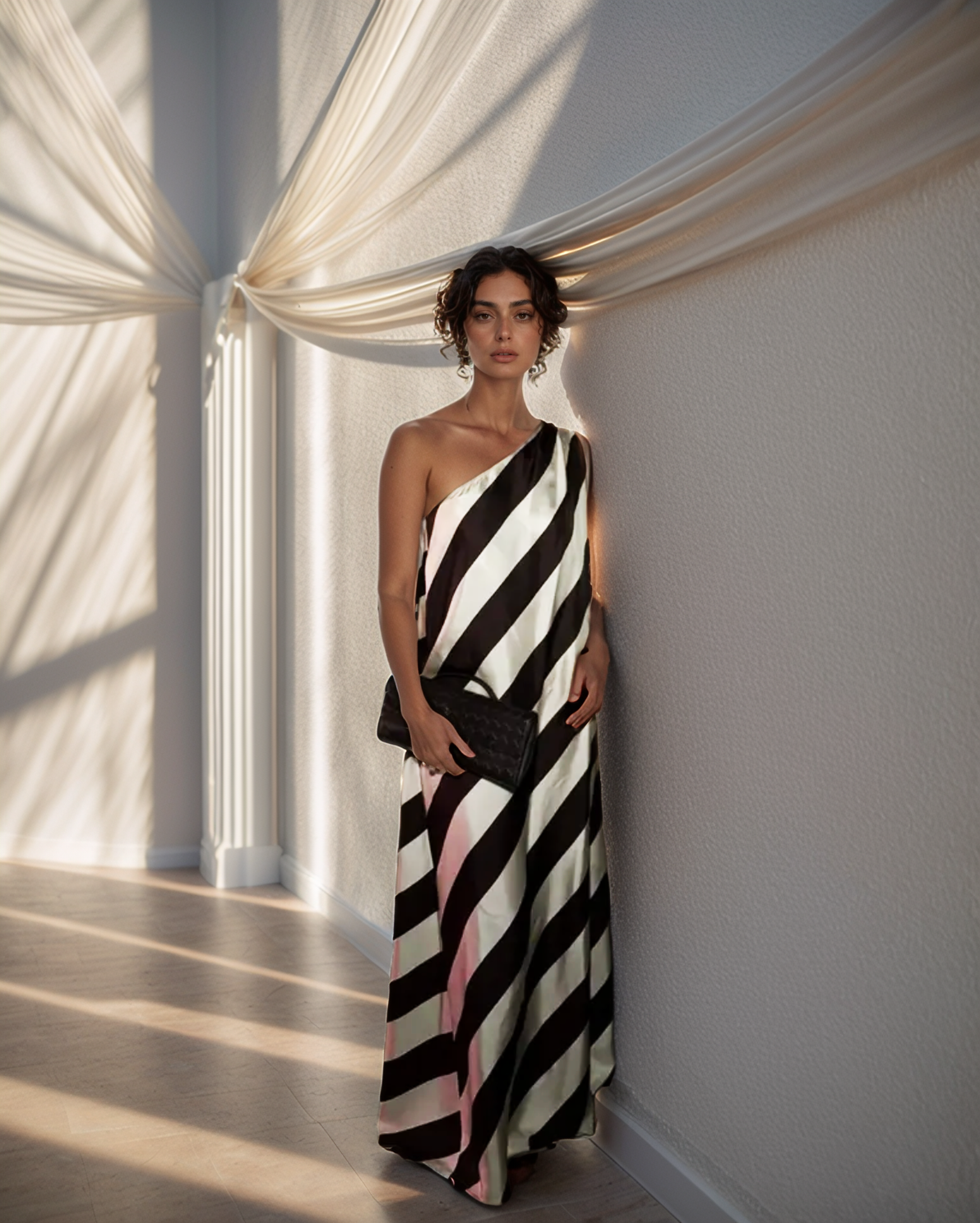 Woman in a black and white striped dress standing in a room with draped curtains.