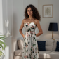 Woman in a floral dress standing in a living room.