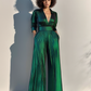 Woman wearing a green metallic jumpsuit against a plain background