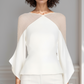 Woman wearing a white and beige top against a plain background