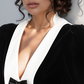 Woman wearing a black velvet outfit with a white collar against a light gray background