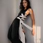 Woman wearing a black and white top against a gray wall