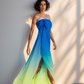 Woman wearing a strapless, floor-length dress with a gradient of blue to green against a neutral background.
