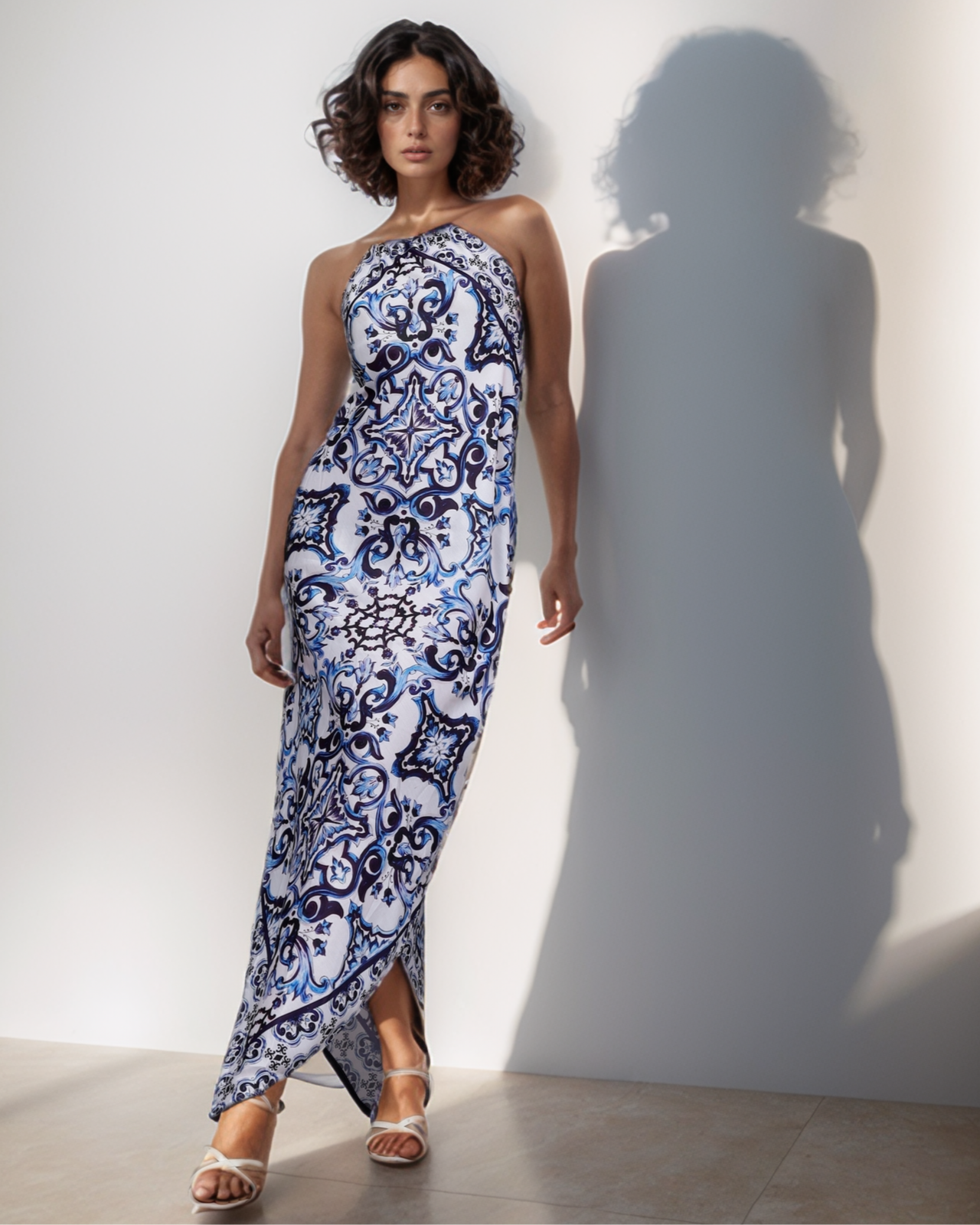 Woman wearing a blue and white patterned dress against a plain background