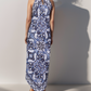 Woman wearing a blue and white patterned dress against a plain background