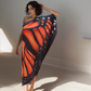 Woman wearing a butterfly-patterned dress against a neutral background