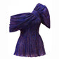 A purple, one-shoulder, crushed fabric top with a distinctive metallic sheen.